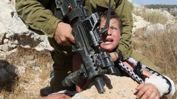 Israeli soldier settings a Palestinian guy during clashes between Israeli protection causes and Palestinian protesters